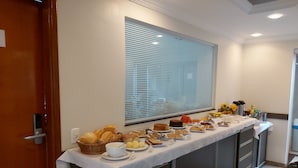 A buffet setup with various food items and a coffee station. - Pousada DuKalango (Caldas Novas)
