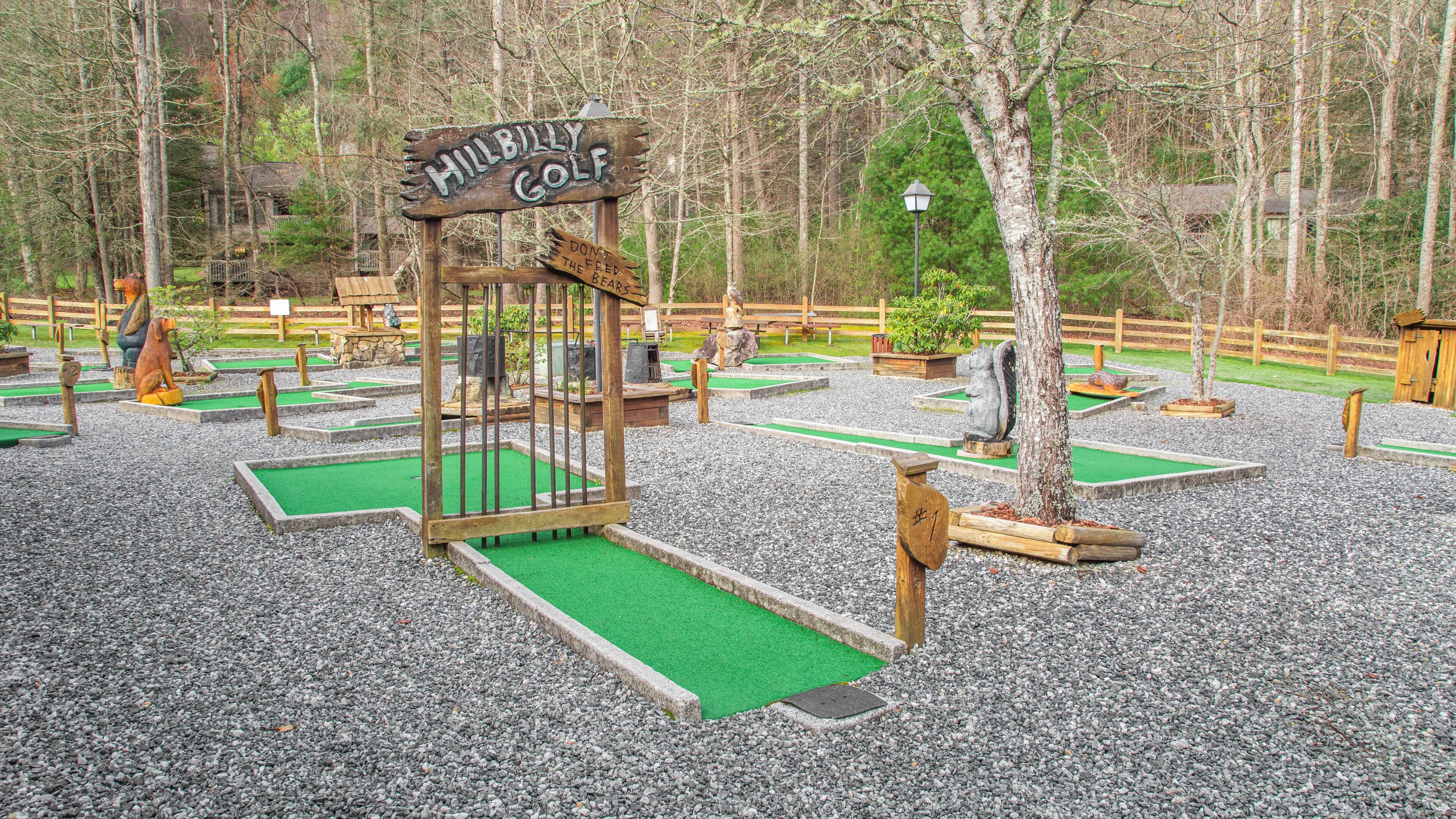 Un parcours de minigolf avec une pancarte en bois sur laquelle on peut lire : « Hillbilly Golf ».