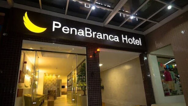 The entrance to PenaBranca Hotel with a glass facade, a visible interior with seating, and a sign above the entrance. - Pena Branca Hotel e Eventos (Santo Antonio de Jesus)