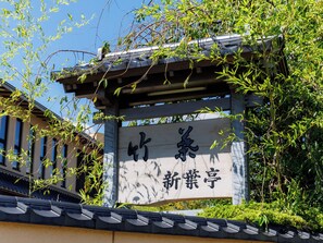 Um edifício japonês tradicional com uma placa que diz '新義教'.
