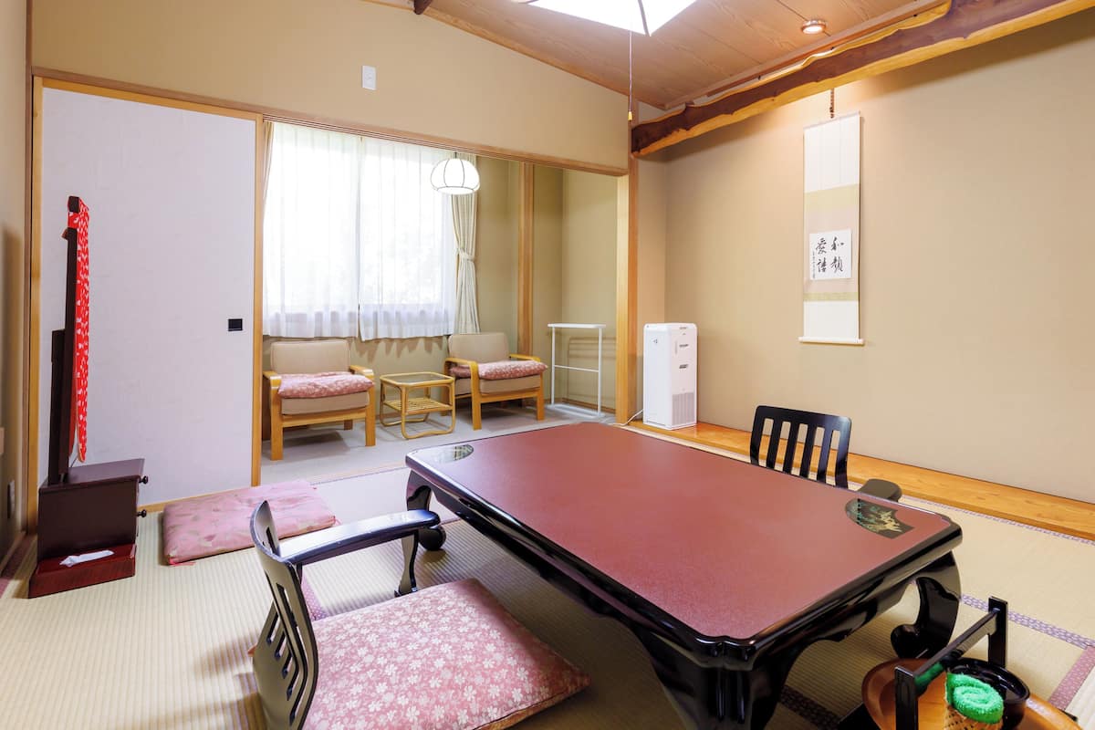 A traditional Japanese room with tatami flooring, a low table, and a sofa.