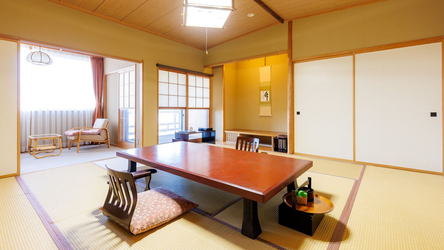 A traditional Japanese room with tatami flooring, a low table, and sliding doors.