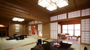 Ein traditioneller japanischer Raum mit Tatami-Bodenbelag, einem niedrigen Tisch und verschiebbaren Türen.