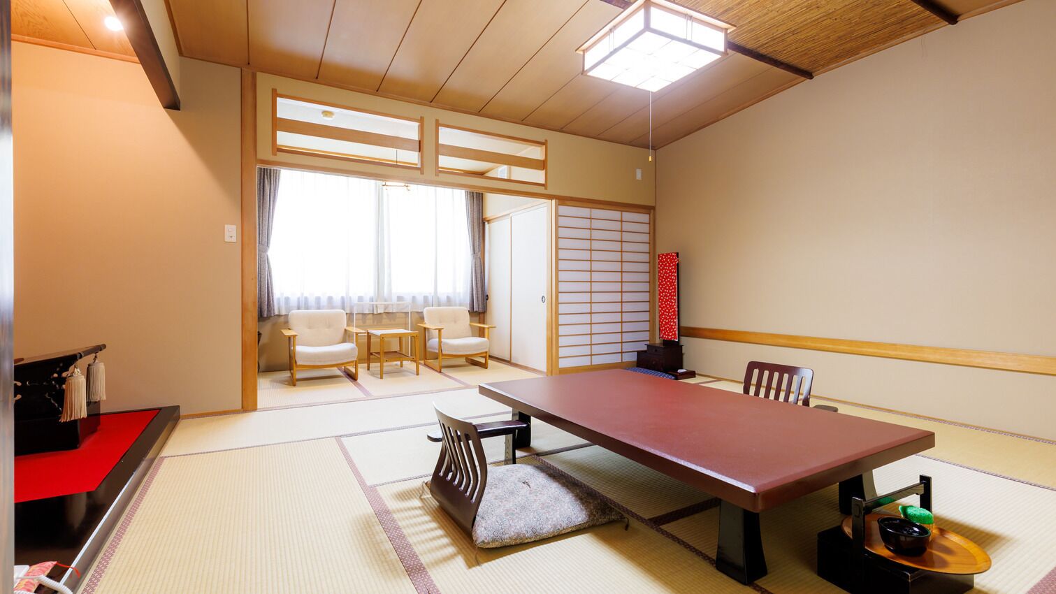A traditional Japanese room with tatami flooring, a low table, and sliding doors.