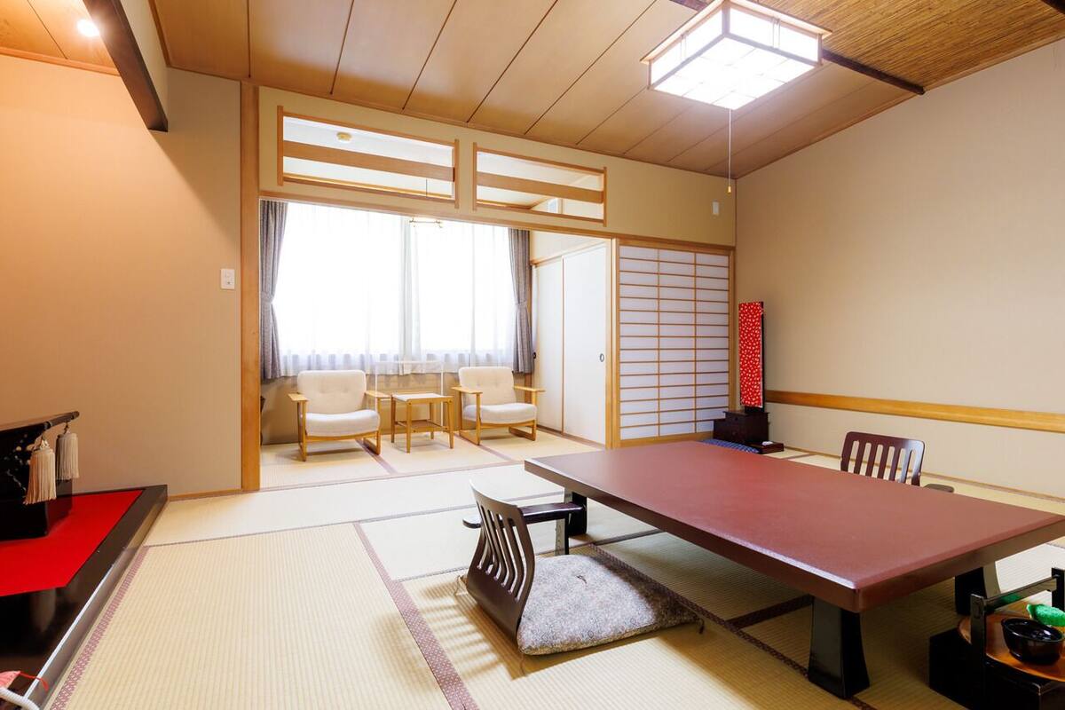 Perinteinen japanilainen huone, jossa on tatamimatto, matala pöytä ja liukuvat ovet.