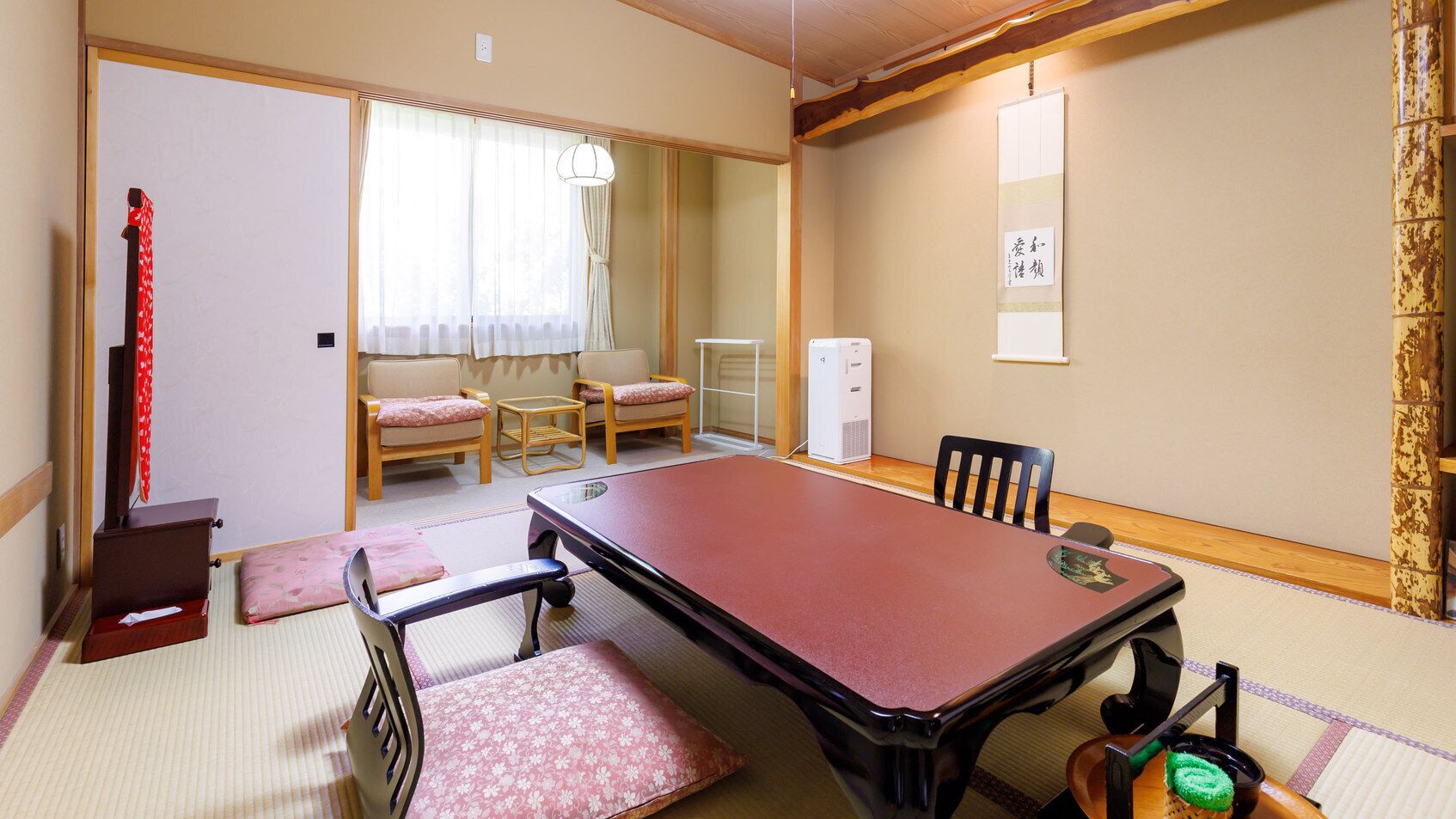A traditional Japanese room with tatami flooring, a low table, and a futon bed.