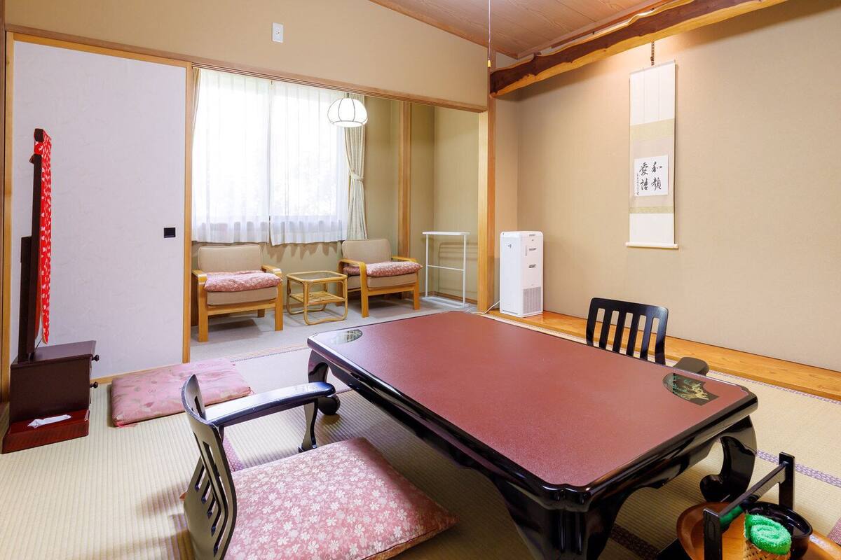 Perinteinen japanilainen huone, jossa on tatamimatto, matala pöytä ja futon-patja.