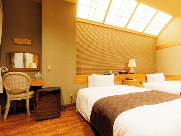 A hotel room with two beds, a desk, a chair, a mirror, a window with blinds, and a lamp. - Chikuba Shinyotei (Hakodate)