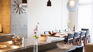 A modern kitchen with a central island, dining table, and chairs. - Hirafu 188 (Kutchan)