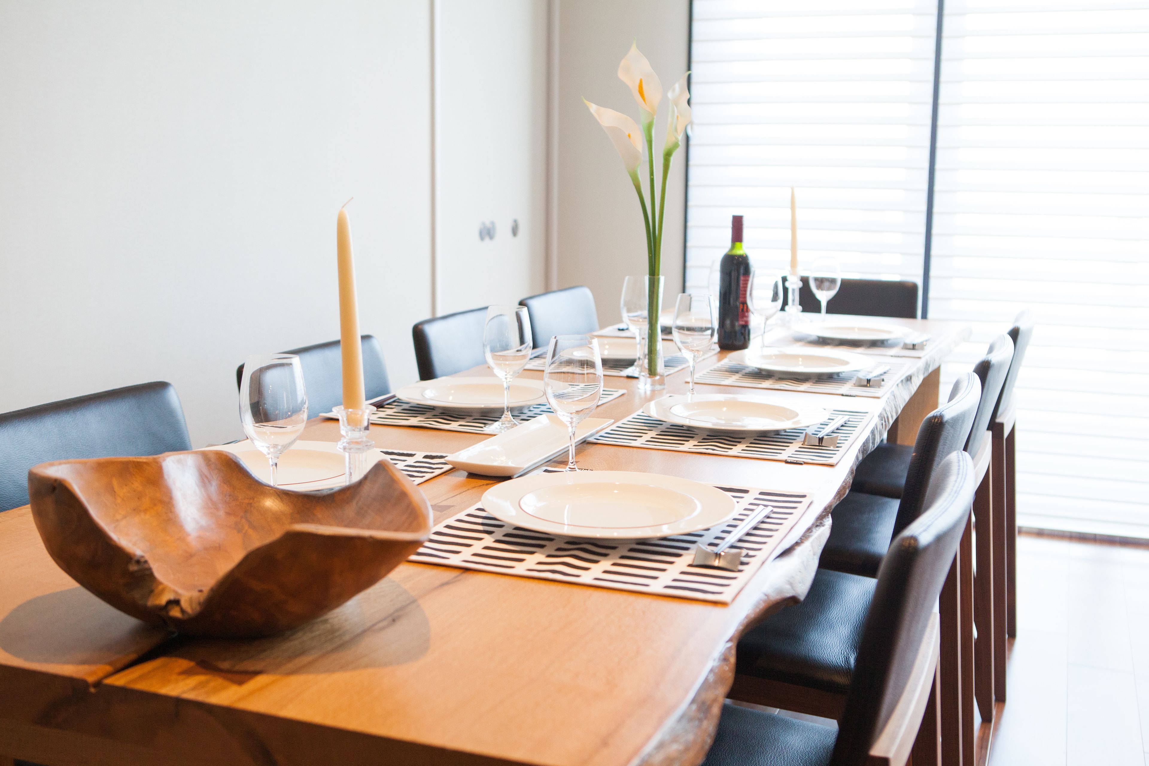 Une table à manger dressée avec des assiettes, des verres et une bougie.
