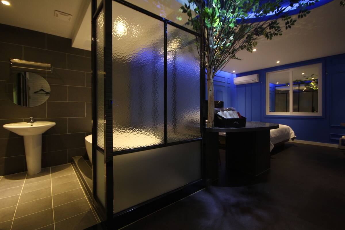 A modern bathroom with a glass partition, a sink, and a mirror.