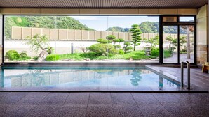A pool area with a view of a landscaped garden and mountains. - Kifu No Sato (Mimasaka)