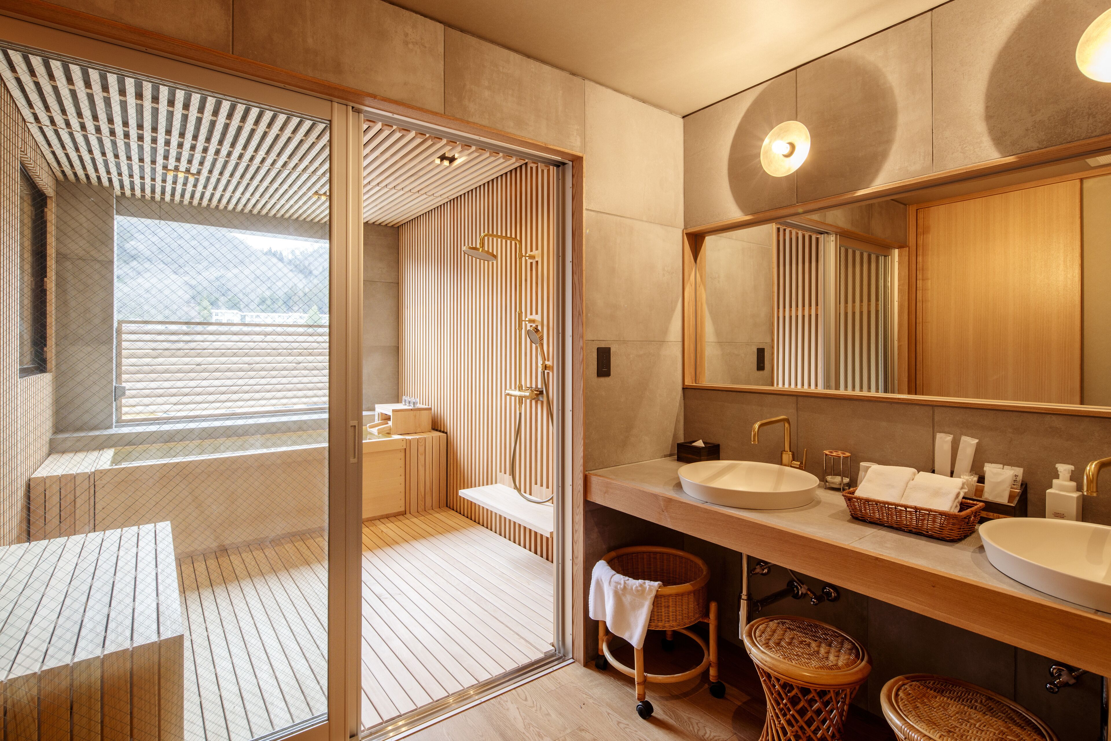 Une salle de bain moderne avec un grand miroir, deux lavabos et un espace douche.