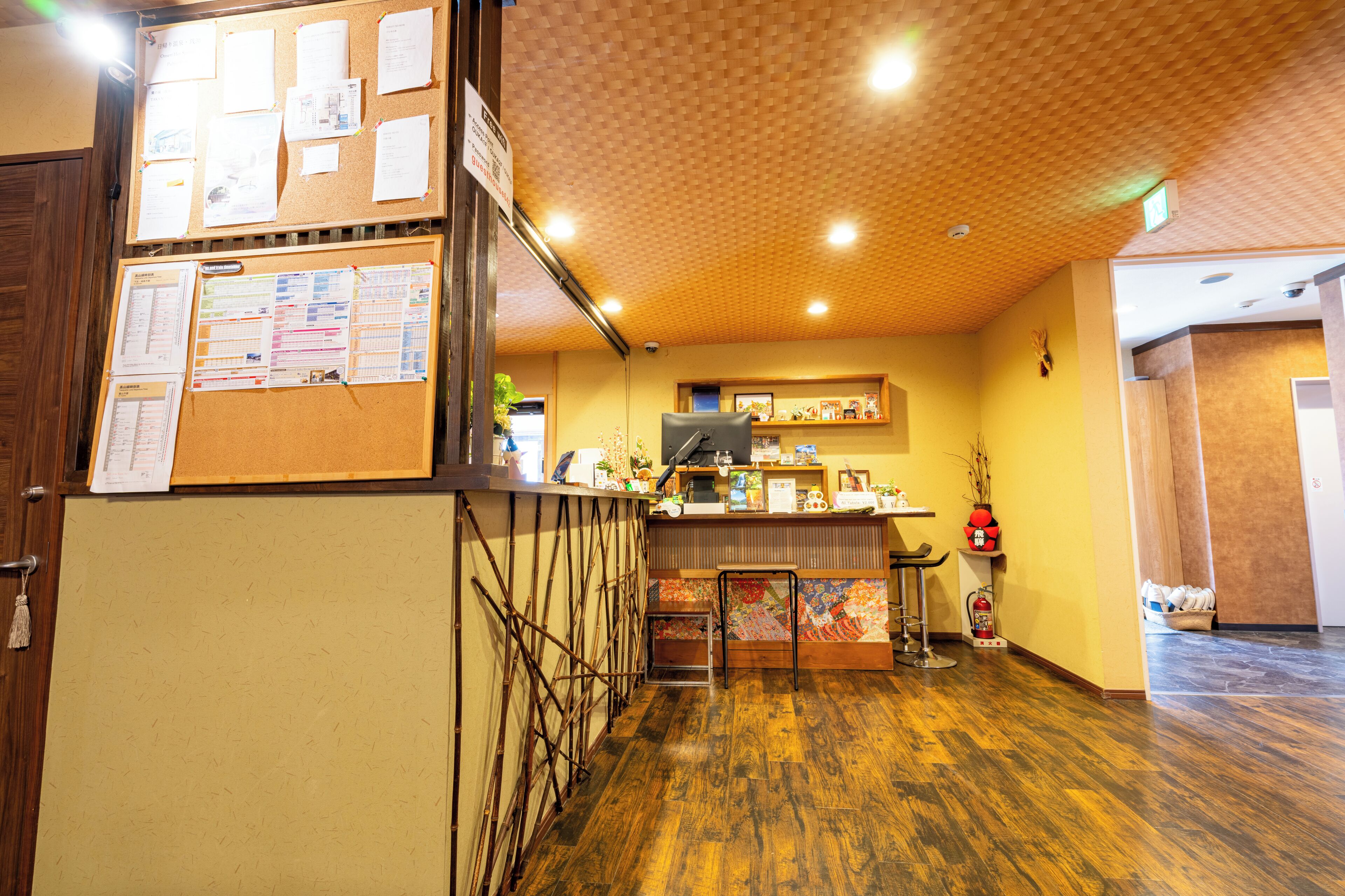 A reception area with a bulletin board, wooden flooring, and a fire extinguisher.