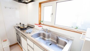 Eine moderne Küche mit Edelstahlgeräten, einer doppelten Spüle und einem Fenster über der Spüle.