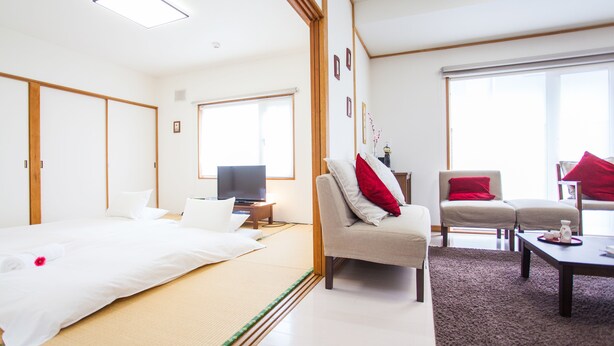 Ein Hotelzimmer mit Bett, Fernseher, Sofa und Couchtisch.