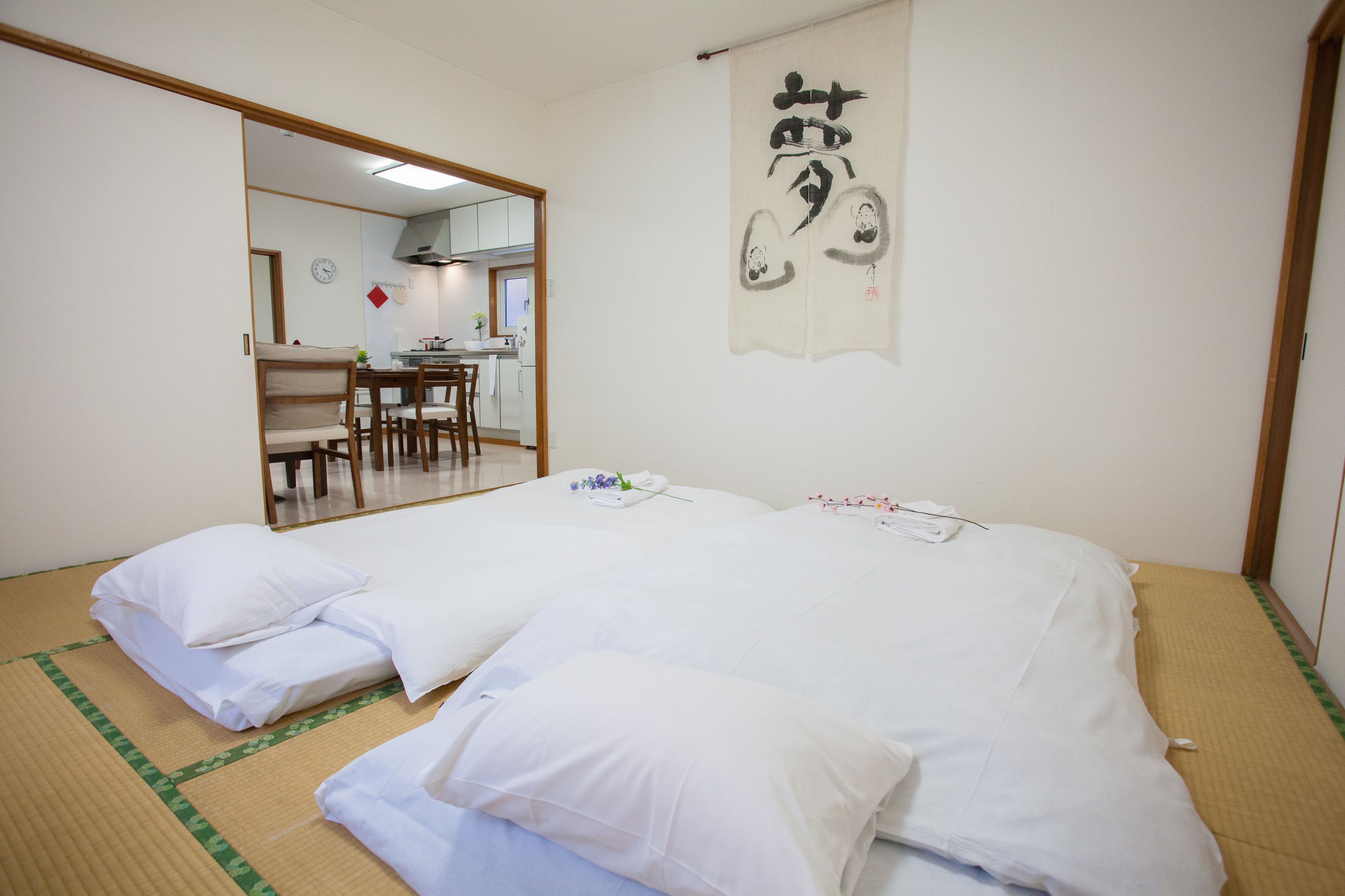 Una habitación japonesa tradicional con suelo de tatami, un futón, un escritorio de madera y un shoji.