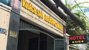 A hotel entrance with a sign indicating 24/24 availability and a staircase leading inside. - Huong Mai 2 Hotel (Ho Chi Minh City)