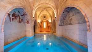 A cathedral interior with a blue-tiled floor, arched ceilings, and illuminated walls.