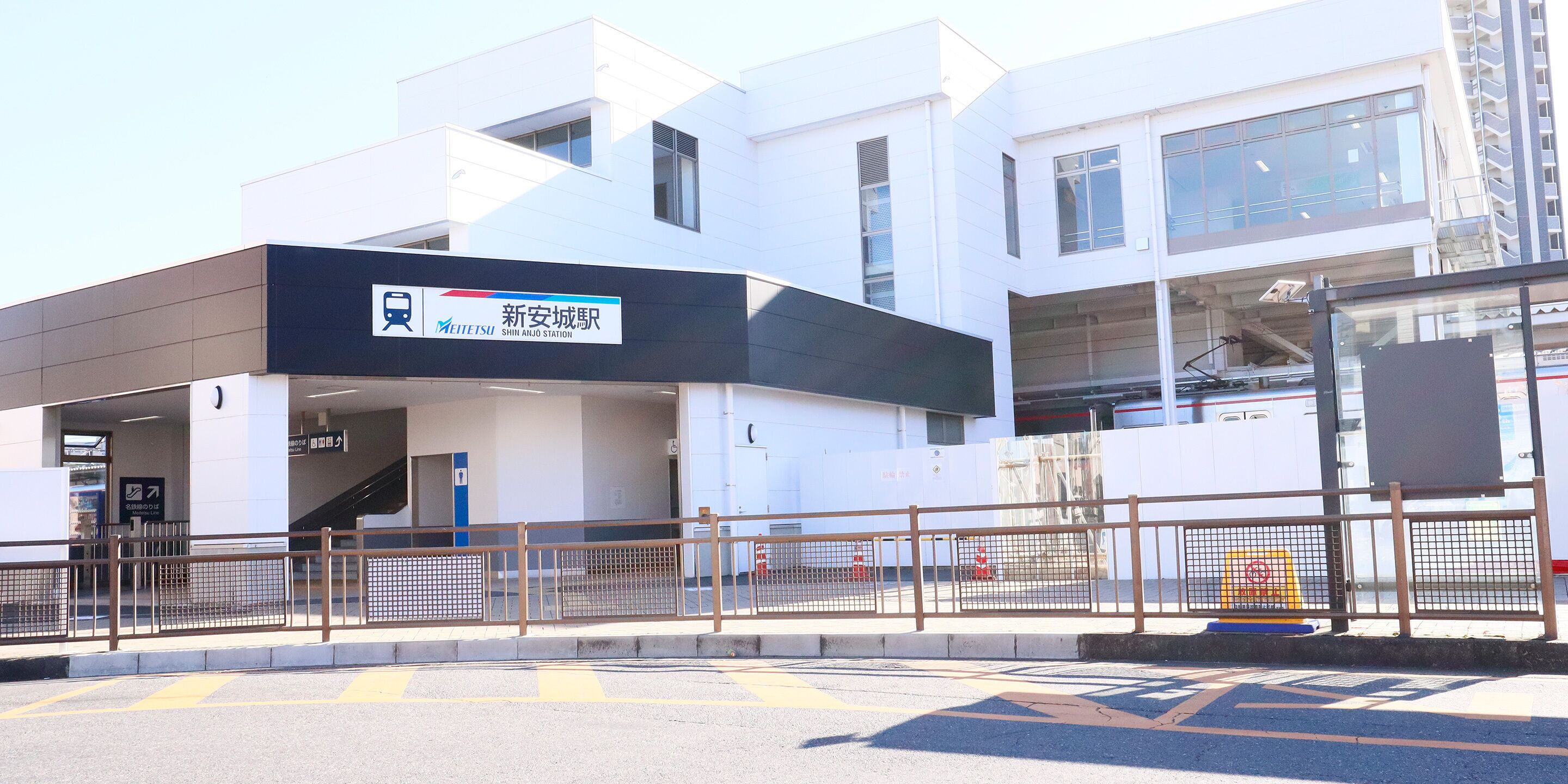 A modern building with a sign reading "Shin-Ai Qing Station".