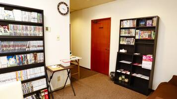 Eine Bibliothek mit Bücherregalen, einem Schreibtisch und einer roten Tür.
