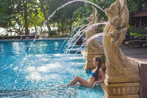 Una piscina con chorros de agua y una estatua.