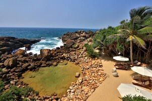 En la playa, sillas reclinables de playa, sombrillas