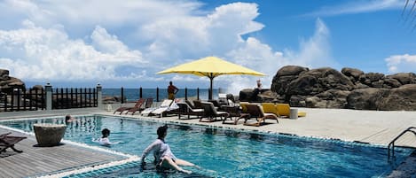 Una piscina al aire libre, tumbonas