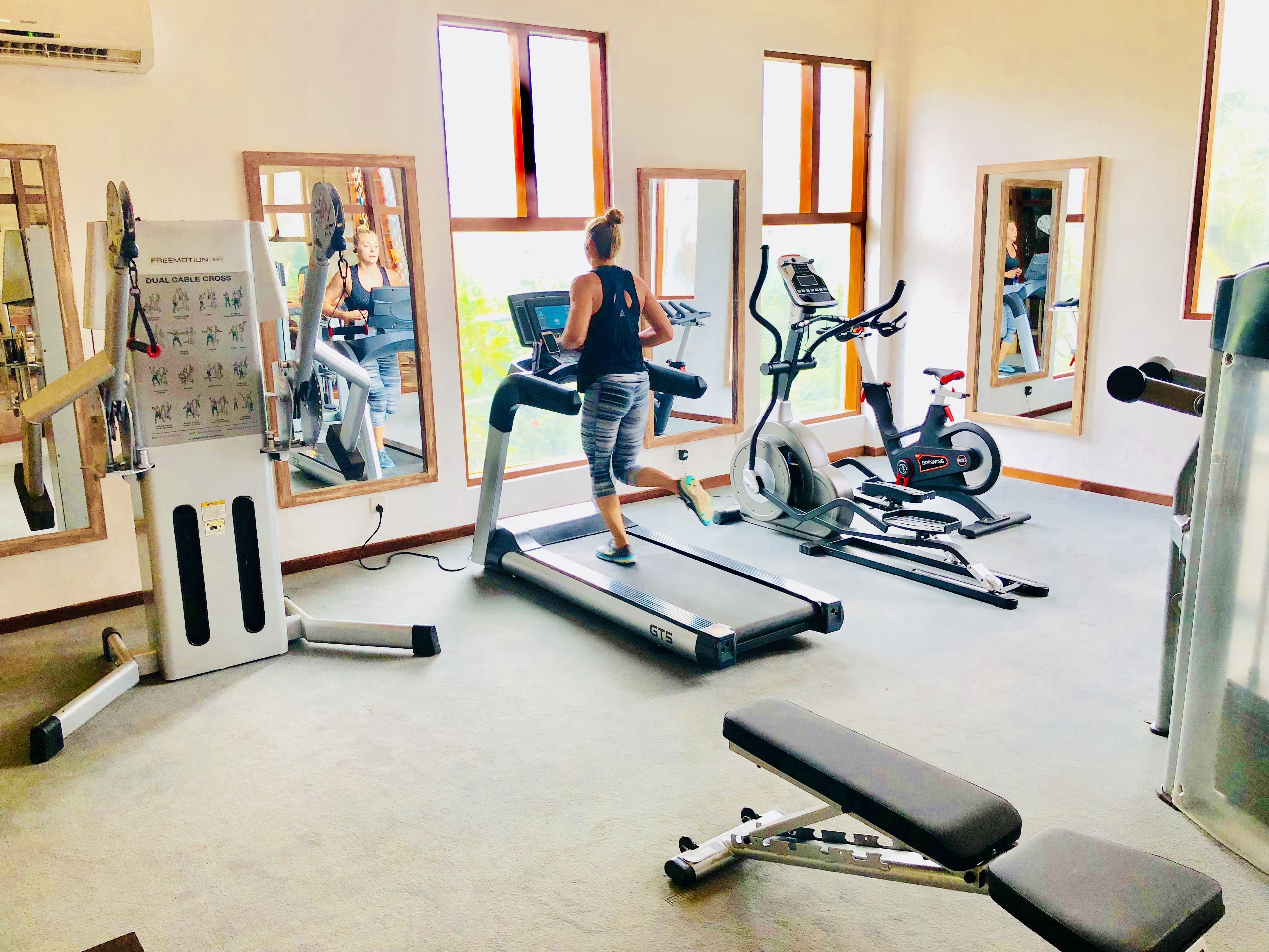 Una palestra con tapis roulant, cyclette e macchinari per pesi.