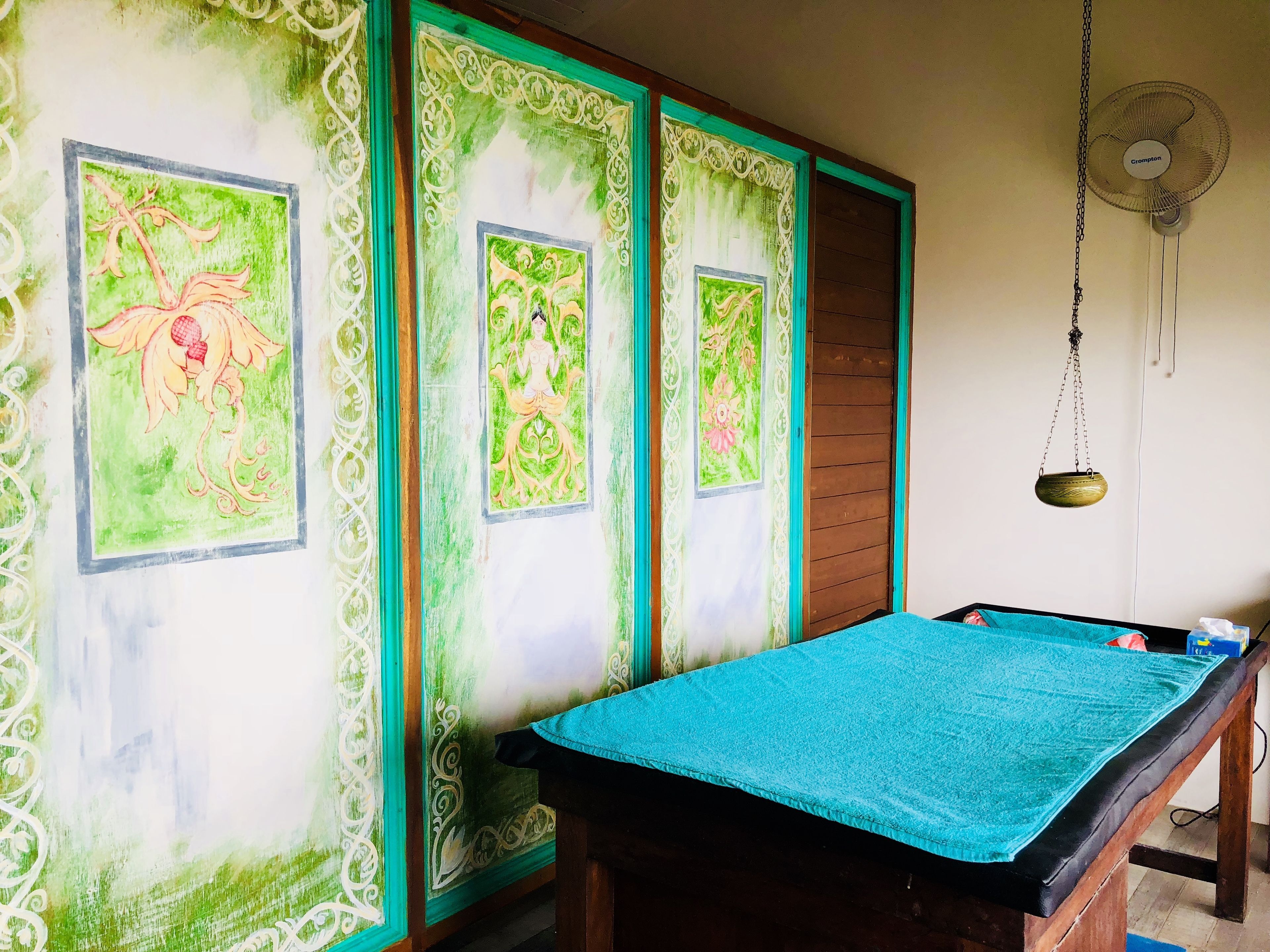A room with a pool table, decorative wall panels, and a ceiling fan.