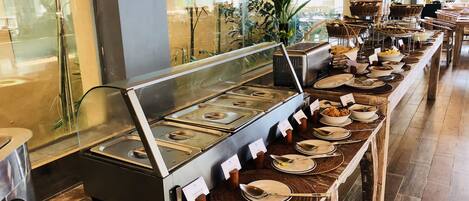A buffet setup with various food stations, including a visible vegetable station.
