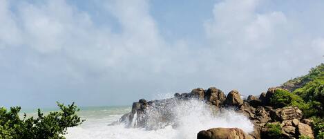 A rocky coastal landscape with waves crashing against the rocks.