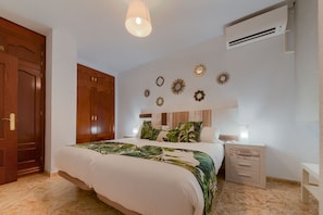 A bedroom with a bed, nightstands, a wardrobe, and wall decorations.