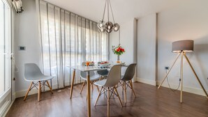 Ein Essbereich mit einem Tisch für vier Personen, einer Kronleuchter und einer Stehlampe.