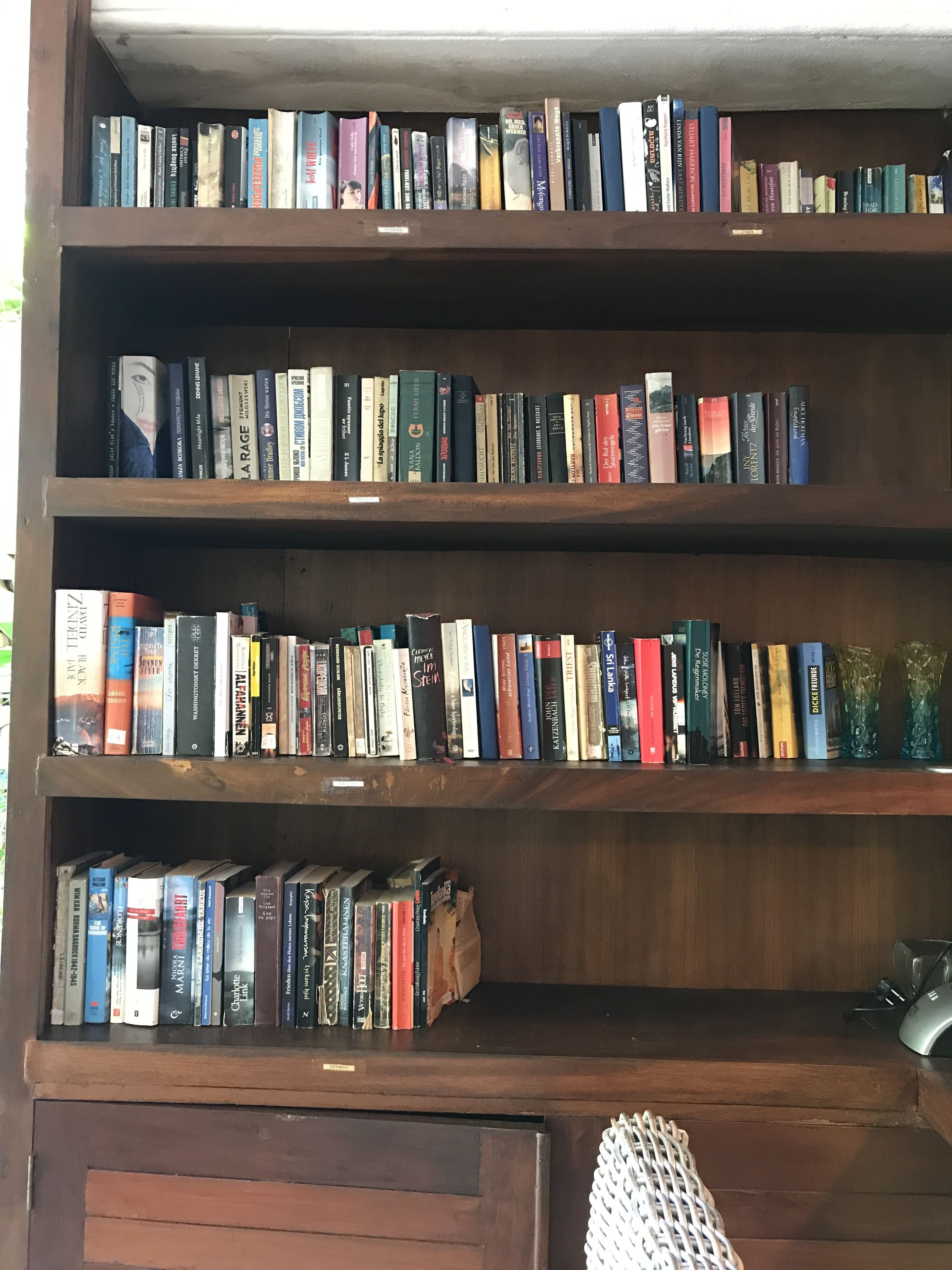 Una estantería de madera con varios estantes llenos de libros.