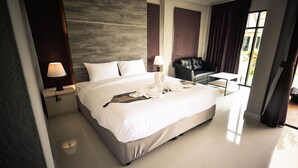 Habitación de hotel moderna con una cama grande, un escritorio, una silla y vistas al exterior.