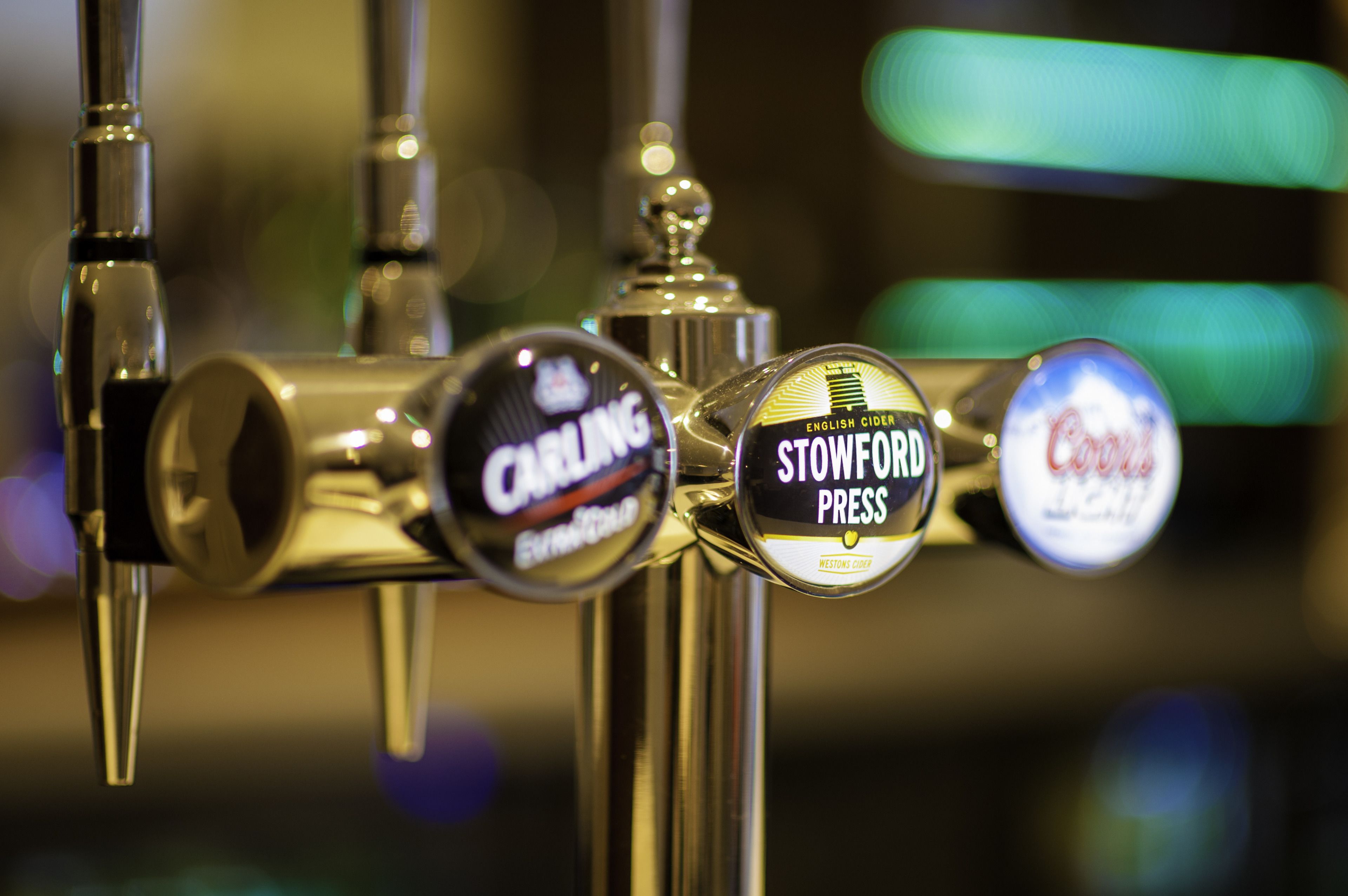 A beer tap with labels for Stowford Press, Cardinal, and Coca-Cola.