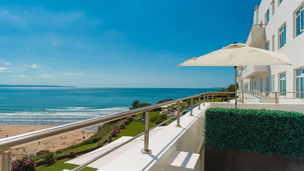 Un balcón con vista a la playa y al océano.