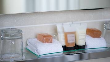 Toiletries neatly arranged on a shelf in a hotel bathroom.