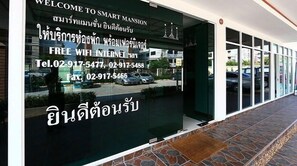 A hotel entrance with a sign offering free WiFi and contact details. - Smart Mansion (Bangkok)