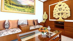 A living room with a sofa, a coffee table, and a decorative wall piece. - Smart Mansion (Bangkok)