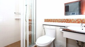 A bathroom with a glass shower enclosure, a white toilet, and a sink with a tiled backsplash. - Smart Mansion (Bangkok)