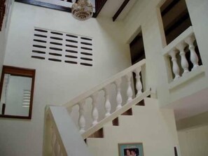A staircase with a balustrade, a ceiling vent, and a framed picture on the wall. - Candles in the Wind (Crown Point)