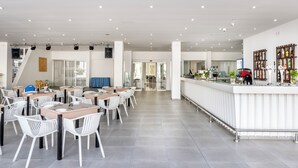 A spacious indoor area with multiple tables and chairs, a reception desk, and a staircase leading to an upper level. - Papantonia Hotel Apartments  (Paralimni)