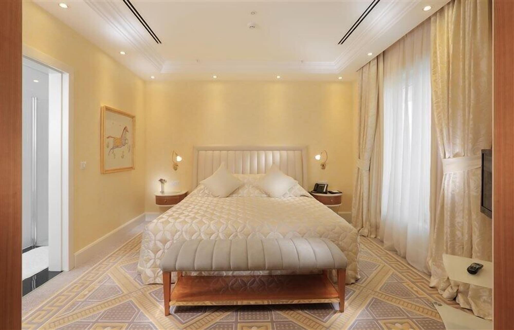Un'ampia camera da letto con un letto grande, due comodini e una testiera.