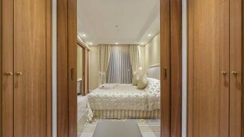 A bedroom with a bed, curtains, and wooden wardrobe doors.