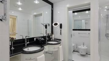 Un baño moderno con dos lavamanos, un espejo grande y una ducha.