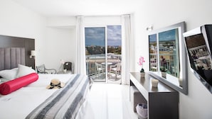 A modern hotel room with a large bed, a balcony with a view, a TV, and a desk. - Hotel Napa Tsokkos (Ayia Napa)