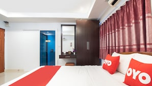 A hotel room with a bed, a desk, a wardrobe, and a bathroom visible through an open door. - OYO 824 Valida Resort (Pattaya)