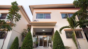A building with a sign reading "VALIDA" at the entrance, surrounded by neatly trimmed trees and a small garden area. - OYO 824 Valida Resort (Pattaya)